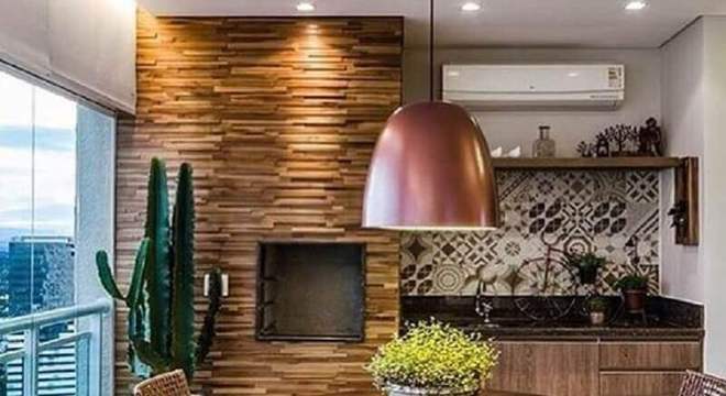 cadeiras para varanda de apartamento com mesa redonda de madeira e churrasqueira