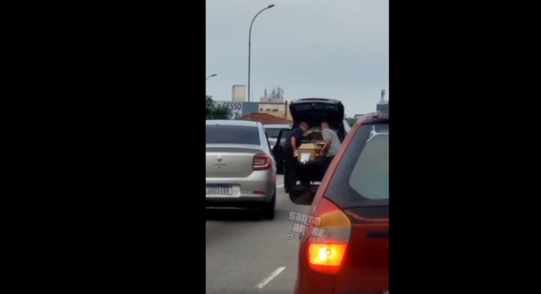 Funcionários de funerária colocam no carro caixão que caiu na pista