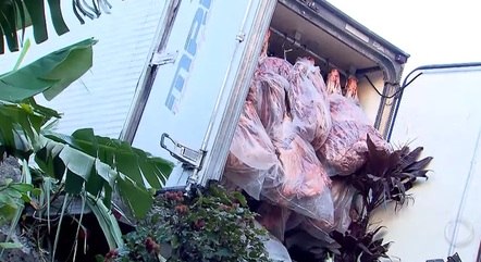 Caminhão, carregado de carne, invade muro de condomínio, em SP

