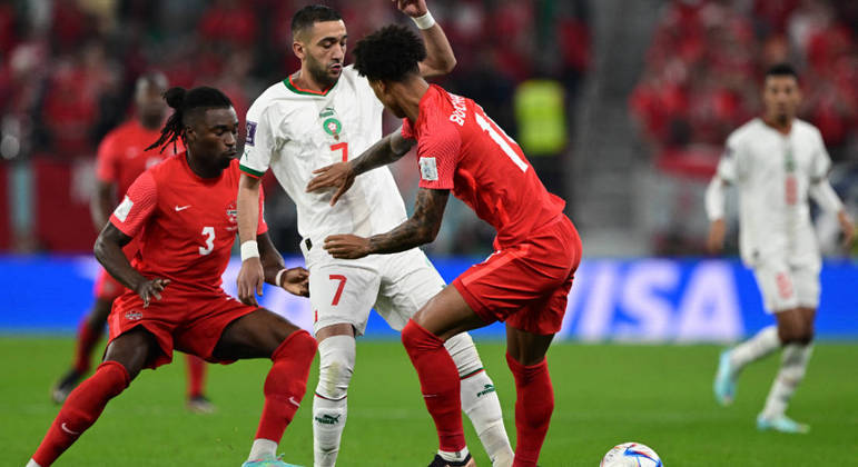  Hakim Ziyech disputa a bola com dois jogadores do Canadá