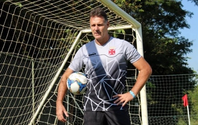 Goleiro Carlos Germano com a bola embaixo dos braços, dentro do gol