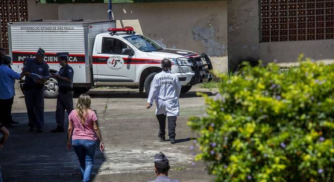 Carro de transporte de cadáveres do IML chega ao local da tragédia, em Suzano