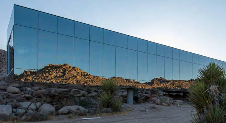 Inspirada no clássico de ficção científica 2001: Uma Odisseia no Espaço, a casa é uma caixa espelhada de 1.700 metros quadrados, que reflete o cenário do deserto ao redor