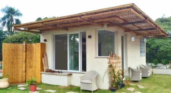 Casa pequena com cerca de bambu na parte externa