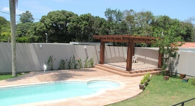 Casas com piscinas com pergolado de madeira