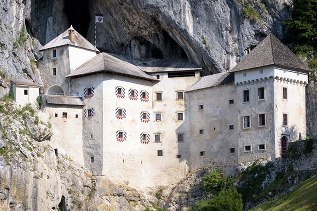 Castelo Predjama - Predjama, Eslovênia -  Castelo renascentista construído dentro de uma boca de caverna no centro-sul da Eslovênia, na região histórica de Inner Carniola. Remonta ao século 13. E se destaca na paisagem do monte rochoso. 