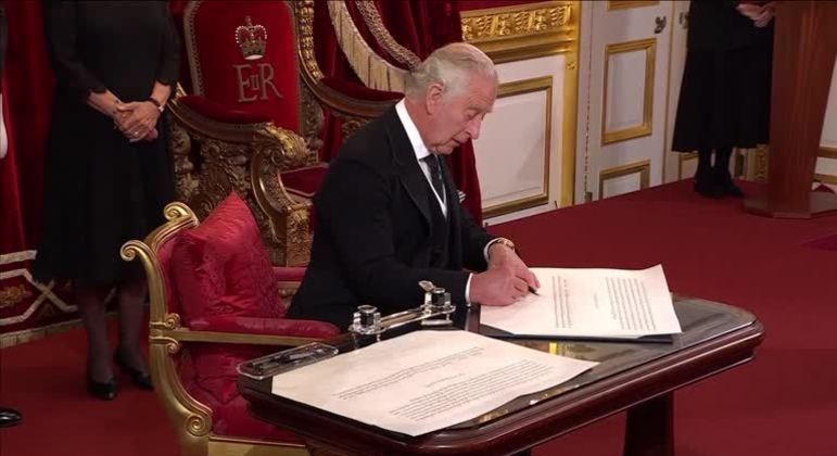 Rei Charles 3º utiliza a própria caneta para assinar livro de visitas