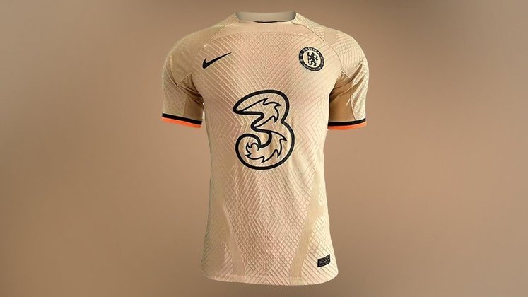 CHELSEA - A terceira camisa do Chelsea é predominantemente dourada, com detalhes em preto e laranja nas mangas. O uniforme se destaca pela sua cor e poucos detalhes, sendo mais 