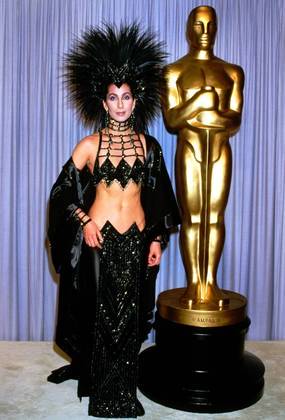 Em 1986, Cher arrasou vestindo um Bob Mackie. Além do modelito impressionante, a cantora e atriz usou uma peruca de plumas. O figurino acabou parecendo uma homenagem a um dos filmes indicados naquele ano: O Beijo da Mulher-Aranha, de Hector Babenco
