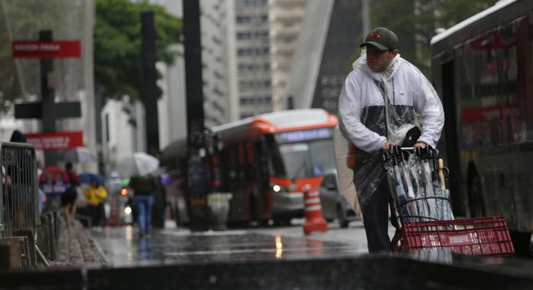 Homem vende guarda-chuvas na avenida Paulista