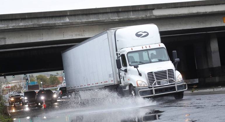 Um caminhão dirige por uma estrada inundada em Hayward, Califórnia 