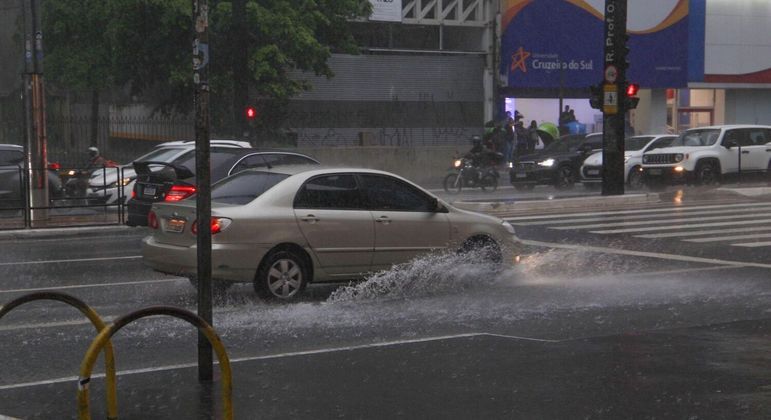 Carros enfrentam asfalto alagado na Avenida Paulista, em SP, na tarde de quarta-feira (8)