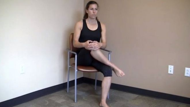 1 - Alongamento em uma cadeiraÉ um dos exercícios recomendados por Bolin e pelo Hospital Ortholndy para aliviar a síndrome do piriforme.Sente-se em uma cadeira e coloque um tornozelo sobre o joelho da outra perna.Mantendo a coluna ereta, use os braços para gentilmente puxar o joelho ao peito, em direção ao ombro oposto.Tente não curvar as costas ou para um dos lados do corpo durante o exercício.Mantenha a posição por 15 segundos e repita cinco vezes de cada lado