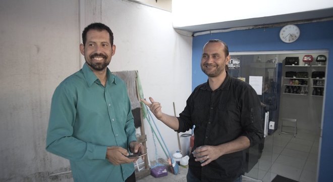 Para complementar a renda, Cleber (esq.) vende perfumes aos passageiros 