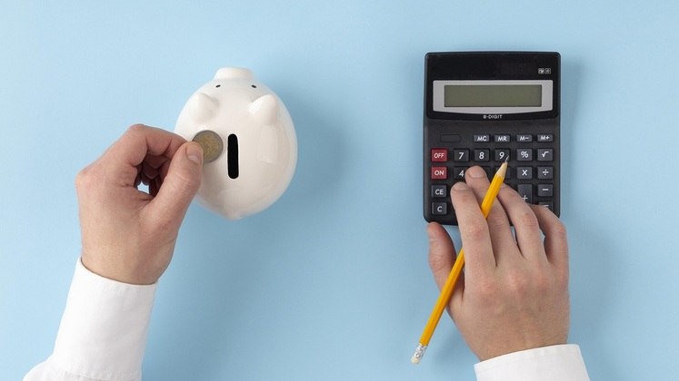 Cofre porquinho branco, moeda e calculadora. Freepik
