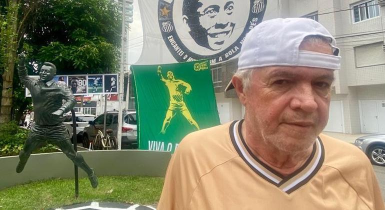 Comerciante Carlos Eduardo Fernandes posa com a estátua de Pelé