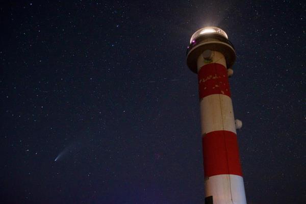 Também na Espanha, uma foto do cometa em uma observação próxima do farol El Tostón, na cidade de El Cotillo