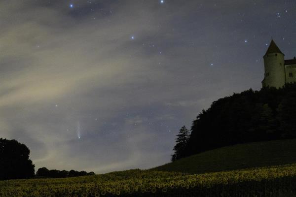 Na Suíça, o cometa foi fotografado com o céu ainda claro e com o castelo de Champvent ao fundo