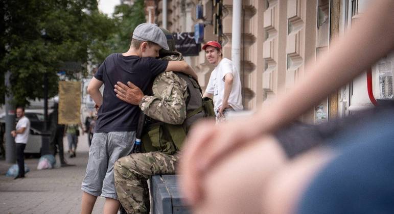 Menino abraça um membro do grupo Wagner em Rostov-on-Don, neste sábado (24)