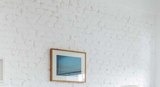 cor branca para quarto decorado com criado mudo de madeira e parede de tijolinho 