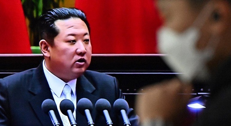 Homem passa por uma televisão que mostra imagens do líder norte-coreano Kim Jong Un