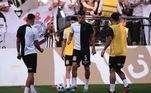 Atletas corintianos no gramado da Neo Química Arena se preparam para a partida contra o Palmeiras