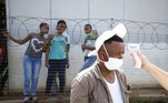 Trabalhador da saúde mede a temperatura de um homem nas ruas de Pietermaritzburg, na África do Sul