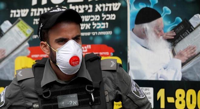 Policial usa máscara durante toque de recolher em Jerusalém por conta do coronavírus