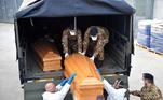 Militares e pessoal de saúde carrega caixões com vítimas de coronavírus em Ferrara, na Itália