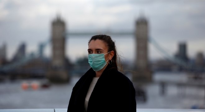 Mulher usa máscara contra o coronavírus em frente à Ponte de Londres