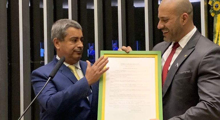 Deputado Coronel Tadeu entrega quadro com decreto de Bolsonaro a Daniel Silveira na tribuna da Câmara