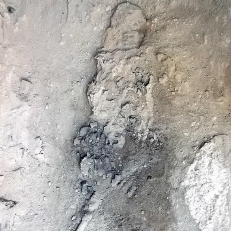 A vítima foi encontrada deitada em uma cama da madeira, enterrada por material vulcânico