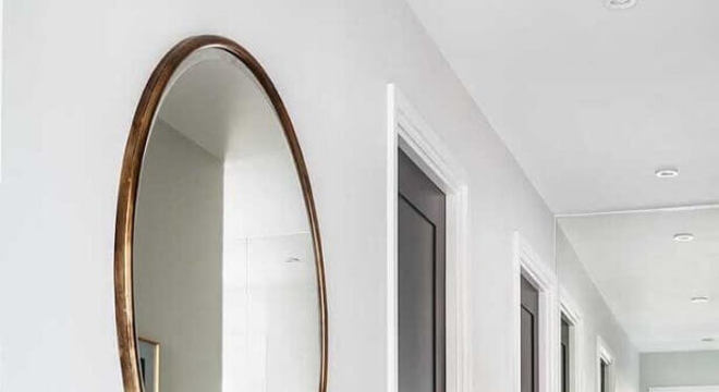 corredor decorado com espelho redondo grande