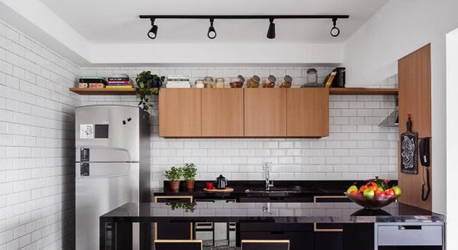 Cozinha com bancada preta e Spot de trilho preto