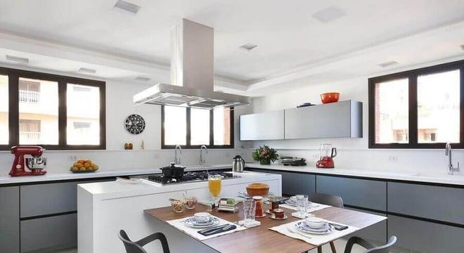 cozinha com ilha central e mesa de madeira acoplada 