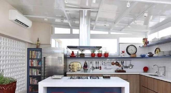 cozinha conceito aberto com ilha e cooktop decorada com banquetas vermelhas 