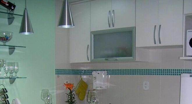 cozinha decorada com pastilhas de vidro verde e bancada de vidro