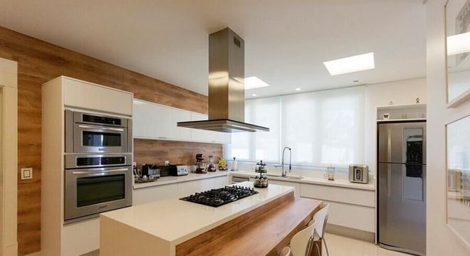cozinha grande com ilha com cooktop e bancada de madeira 