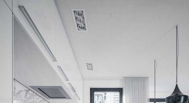cozinha na cor branca decorada com piso de madeira e pendente preto 