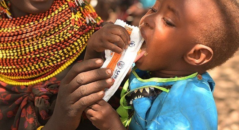 Criança come pasta de amendoim rica em nutrientes, no Quênia