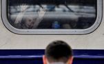 Dentro do trem, menino olha para o homem que está do lado de fora, na estação de trem em Kiev, capital da Ucrânia