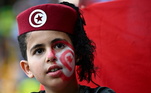 Torcedora mirim da Tunísia durante partida contra a Austrália, no último sábado (26). Além da boina com a bandeira do país, a garota fez uma bela pintura no rosto para homenagear a nação