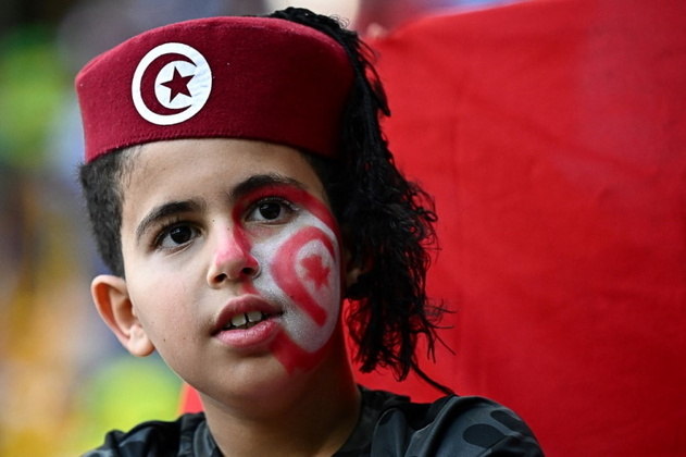 Torcedora mirim da Tunísia durante partida contra a Austrália, no último sábado (26). Além da boina com a bandeira do país, a garota fez uma bela pintura no rosto para homenagear a nação