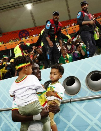 Gana Gueye, volante senegalês, segura os filhos no colo após a vitória de sua seleção sobre o Equador, que garantiu vaga nas oitavas de final
