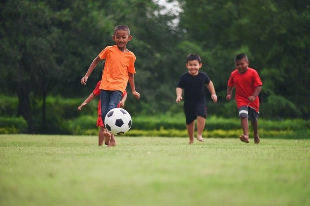 Crianças jogam futebol. Freepik