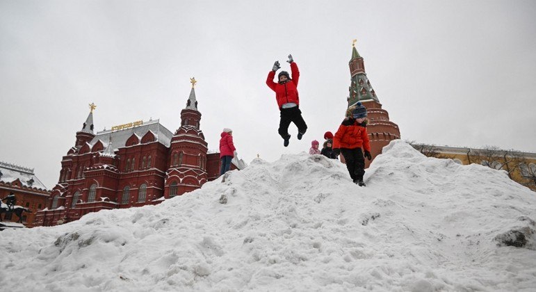 Crianças brincam na neve em uma praça de Moscou, Rússia