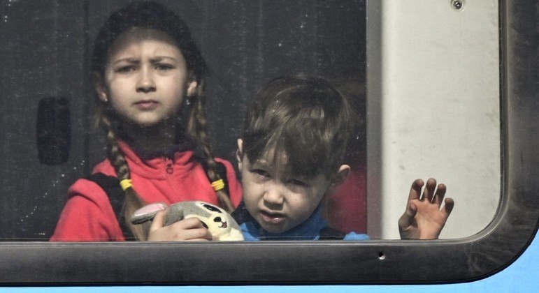 Crianças da Ucrânia em trem com destino à fronteira do país
