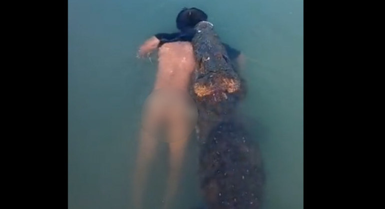 Visitantes do parque filmaram o crocodilo nadando com homem morto