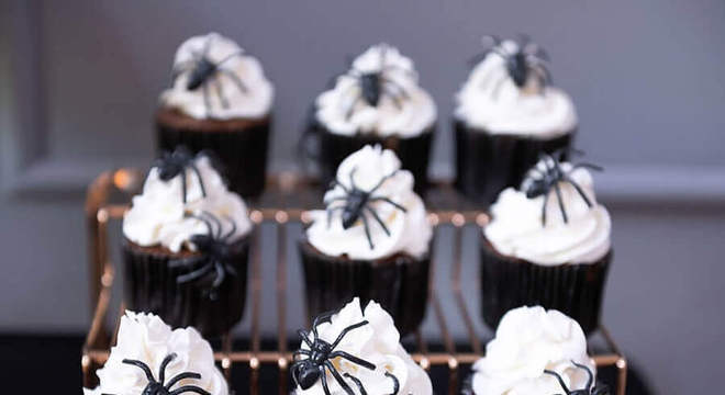 cupcake decorado com aranhas de brinquedo para festa de Dia das Bruxas