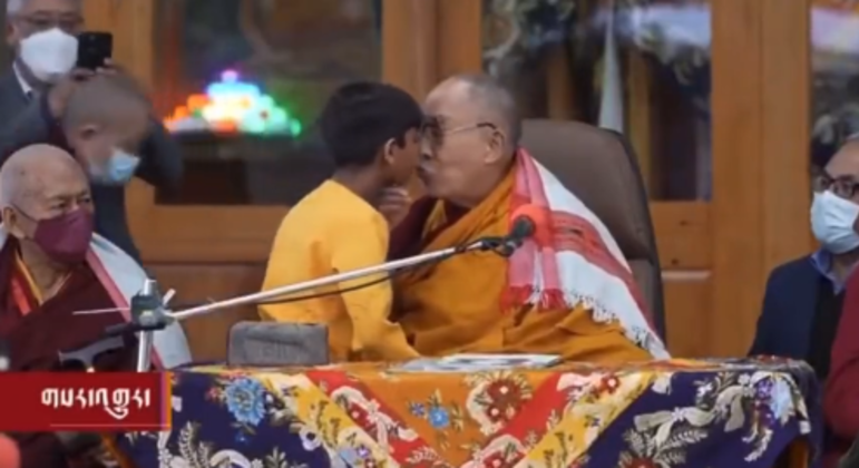 Líder espiritual Dalai Lama no momento em que beija menino nos lábios durante um evento